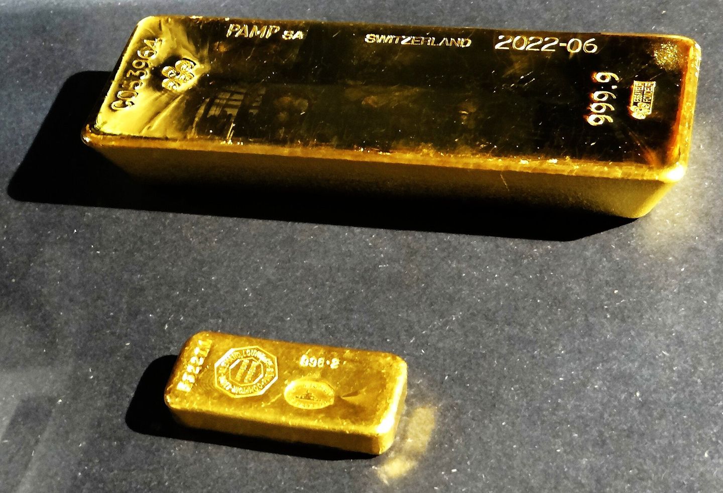 Un lingot d'or estampé d'un kilogramme et un lingotin coulé plus petit.